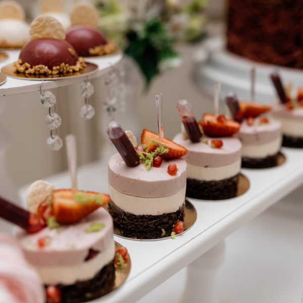 Delicious mousse desserts decorated with strawberries at the ban Delicious mousse desserts decorated with strawberries at the banquet candy bar